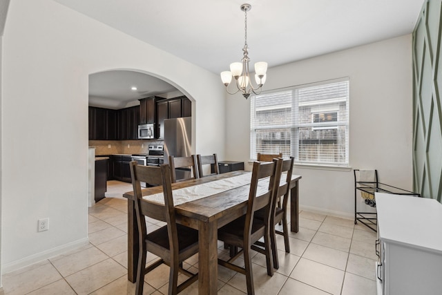 20423 Barrel Run Dr, Hockley, TX 77447 - dining space with arched walkways, a chandelier, light tile patterned flooring, and baseboards
