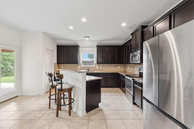20423 Barrel Run Dr, Hockley, TX 77447 - kitchen with appliances with stainless steel finishes, light stone counters, decorative backsplash, recessed lighting, and light tile patterned floors
