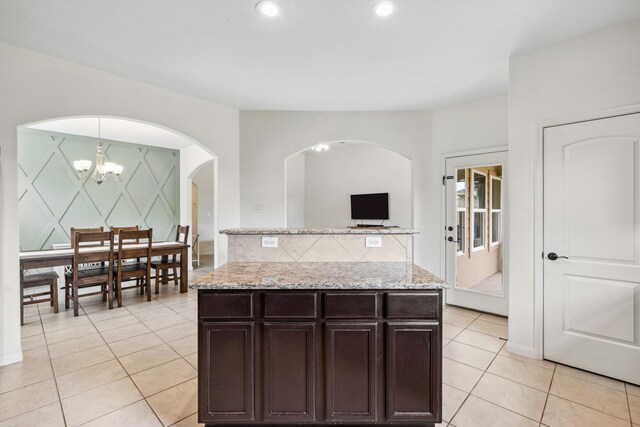 20423 Barrel Run Dr, Hockley, TX 77447 - kitchen featuring arched walkways, light tile patterned flooring, light stone counters, dark brown cabinetry, and recessed lighting