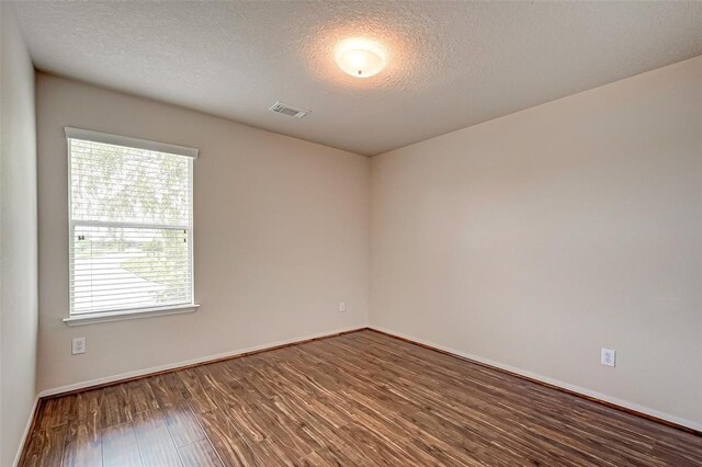 15131 Live Oak Bend Way, Cypress, TX 77429 - empty room featuring wood finished floors, a textured ceiling, and baseboards