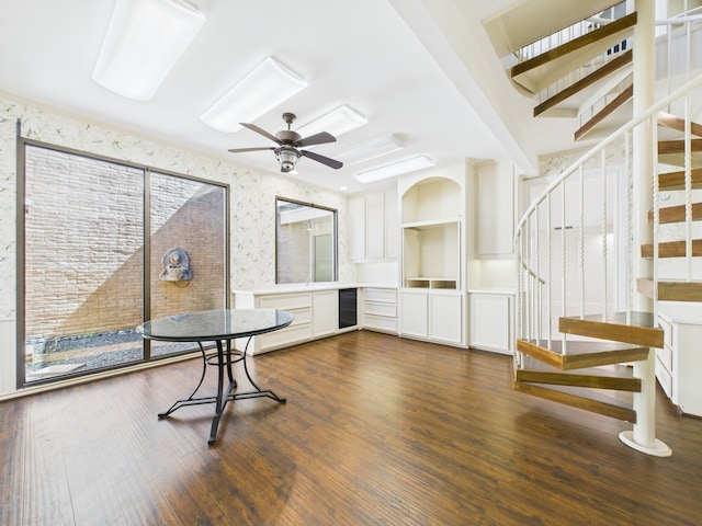 7608 Del Monte Dr, Houston, TX 77063 - unfurnished dining area with stairway, wallpapered walls, dark wood-style flooring, a ceiling fan, and wine cooler