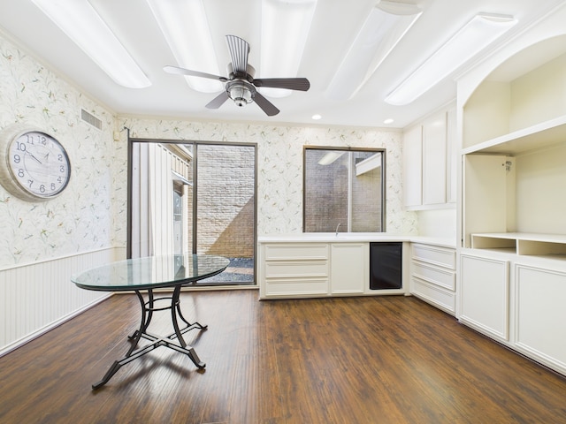 7608 Del Monte Dr, Houston, TX 77063 - unfurnished dining area featuring wallpapered walls, a wainscoted wall, dark wood-style floors, a ceiling fan, and a sink