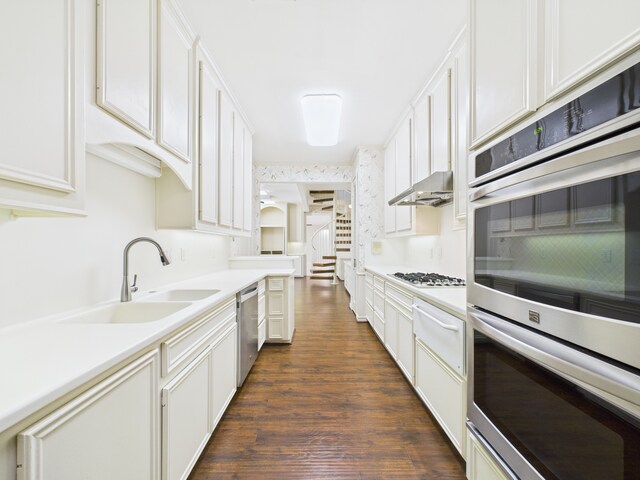7608 Del Monte Dr, Houston, TX 77063 - kitchen with stainless steel appliances, a sink, dark wood finished floors, a warming drawer, and ventilation hood