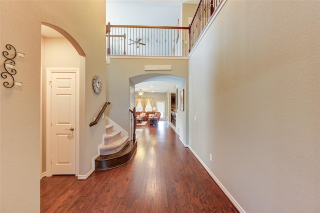 9710 Wild Orange Ct, Spring, TX 77379 - foyer entrance featuring wood finished floors, stairs, a high ceiling, arched walkways, and baseboards