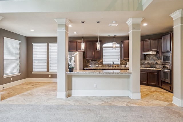 14603 Hampton Green Ln, Houston, TX 77044 - kitchen featuring stainless steel appliances, decorative columns, under cabinet range hood, dark brown cabinetry, and recessed lighting