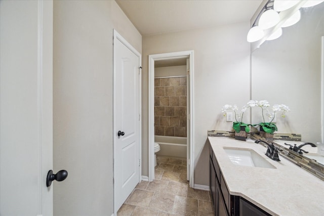 14603 Hampton Green Ln, Houston, TX 77044 - bathroom with vanity, toilet, stone finish flooring, baseboards, and washtub / shower combination