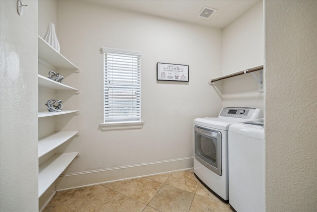 14603 Hampton Green Ln, Houston, TX 77044 - laundry room with washer and dryer, light tile patterned floors, and baseboards