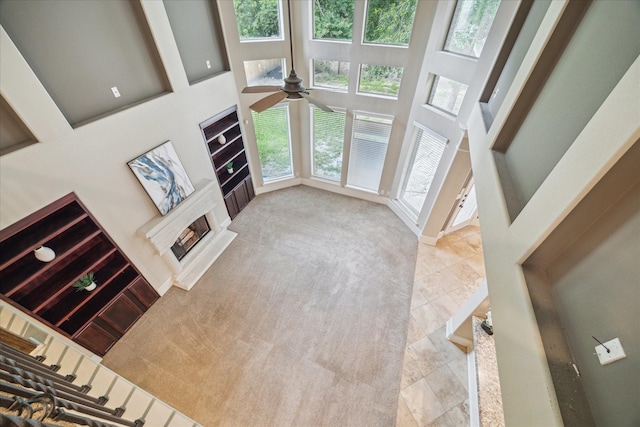 14603 Hampton Green Ln, Houston, TX 77044 - unfurnished living room featuring a ceiling fan, a high ceiling, carpet, and a fireplace with raised hearth