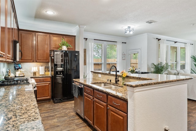 31318 Evergreen Park Ln, Conroe, TX 77385 - kitchen featuring appliances with stainless steel finishes, a sink, ornamental molding, dark wood finished floors, and light stone countertops
