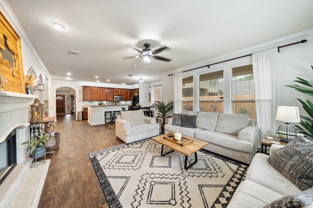 31318 Evergreen Park Ln, Conroe, TX 77385 - living room featuring arched walkways, ceiling fan, a tiled fireplace, recessed lighting, and dark wood-style floors