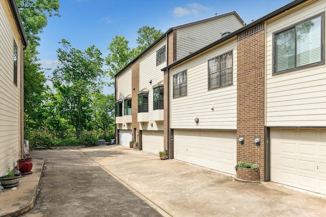 19 Crestwood Dr Unit 4, Houston, TX 77007 - view of side of property featuring brick siding, an attached garage, and driveway
