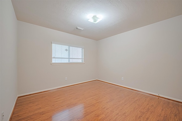 8143 Solara Bnd, Houston, TX 77083 - unfurnished room with wood finished floors, baseboards, and a textured ceiling