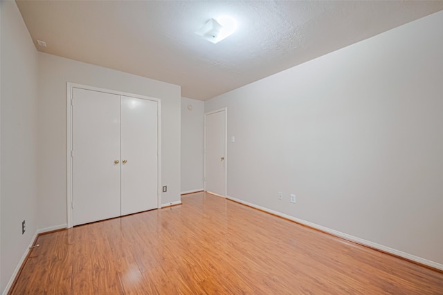 8143 Solara Bnd, Houston, TX 77083 - unfurnished bedroom with light wood finished floors, baseboards, and a closet