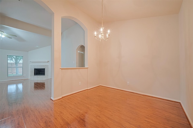 8143 Solara Bnd, Houston, TX 77083 - unfurnished dining area featuring wood finished floors, a ceiling fan, baseboards, a tile fireplace, and a chandelier