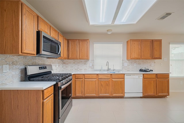 8143 Solara Bnd, Houston, TX 77083 - kitchen with stainless steel appliances, a sink, light countertops, tasteful backsplash, and light tile patterned floors