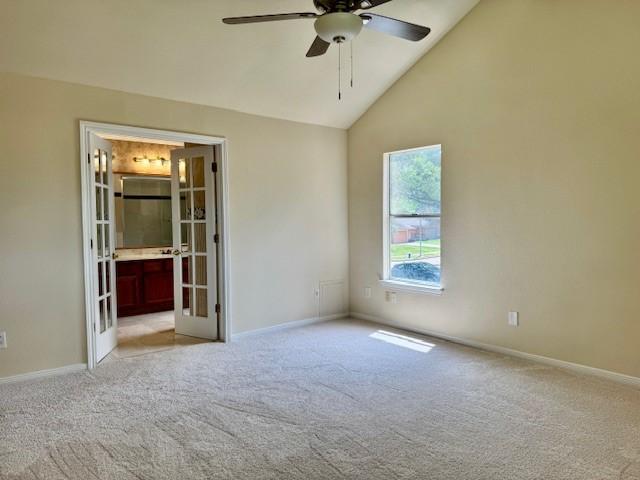 15326 Lindita Dr, Houston, TX 77083 - unfurnished bedroom featuring french doors, light colored carpet, baseboards, high vaulted ceiling, and ensuite bath