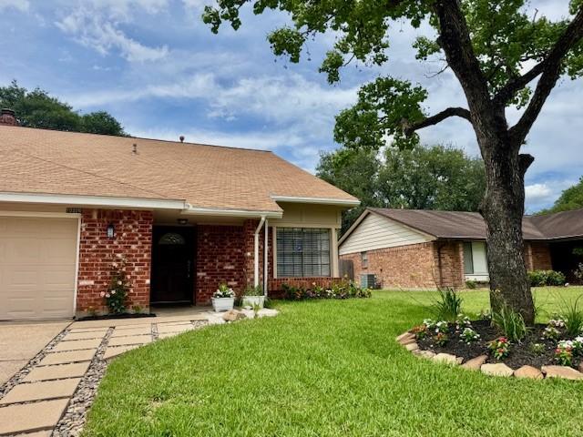 15326 Lindita Dr, Houston, TX 77083 - view of front facade featuring brick siding, a front yard, and an attached garage