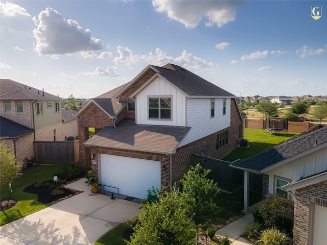 31334 Balsam Hawk Ln, Hockley, TX 77447 - view of front of home with board and batten siding, a trampoline, concrete driveway, a garage, and brick siding