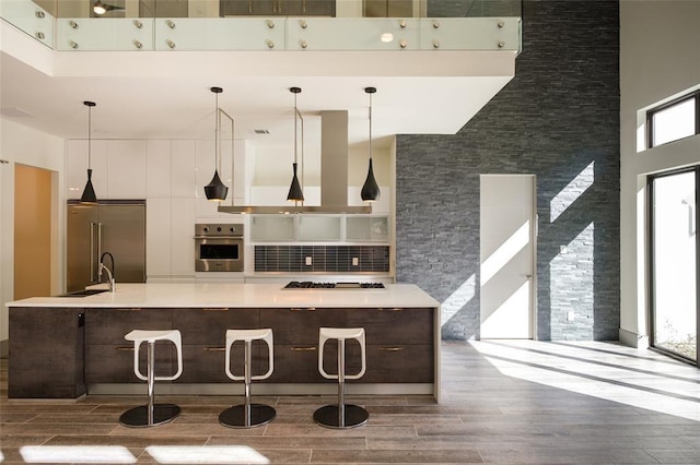 2214 Hewitt Dr, Houston, TX 77018 - kitchen with appliances with stainless steel finishes, wood finished floors, a high ceiling, a sink, and light countertops