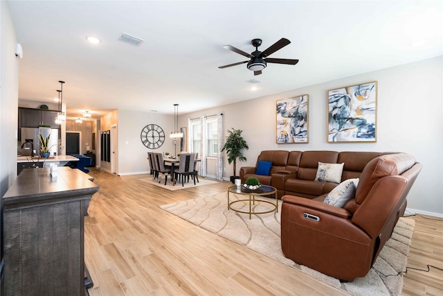 8414 Bay Ridge Cir, Baytown, TX 77523 - living room featuring baseboards, a ceiling fan, light wood-type flooring, recessed lighting, and a chandelier