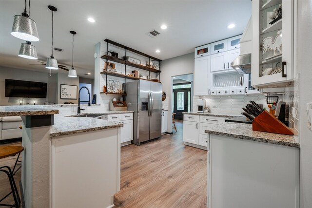 35 Disher Cir, Huffman, TX 77336 - kitchen with stainless steel fridge, a sink, a peninsula, decorative backsplash, and recessed lighting