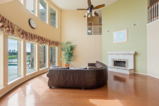 9710 Lansing Meadows Dr, Humble, TX 77396 - living area with high vaulted ceiling, wood finished floors, plenty of natural light, a tile fireplace, and ceiling fan