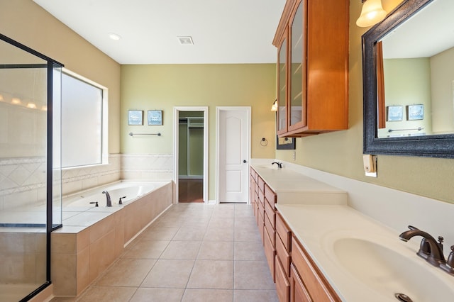 9710 Lansing Meadows Dr, Humble, TX 77396 - full bathroom with vanity, a garden tub, a stall shower, tile patterned flooring, and a walk in closet