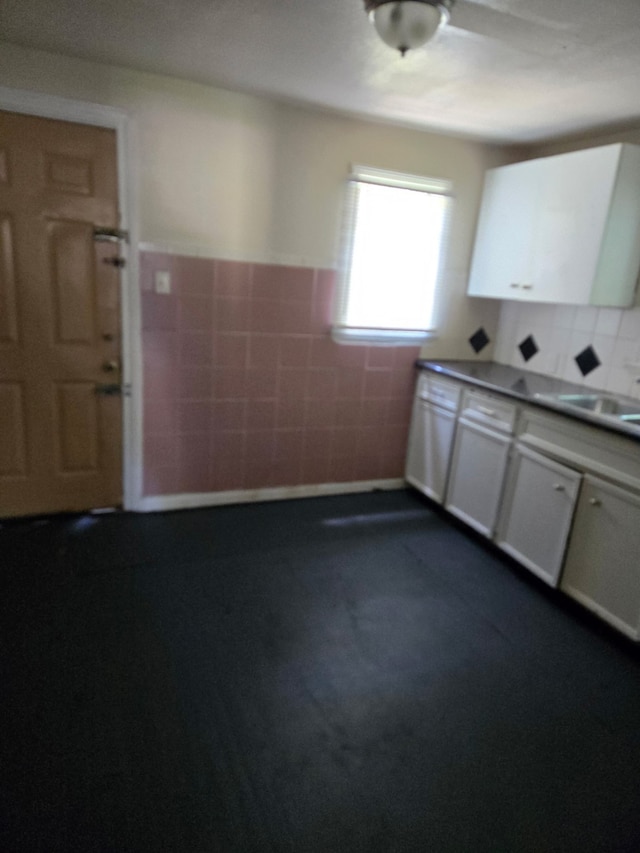 4412 Alvin St, Houston, TX 77051 - kitchen with tile walls, a sink, white cabinetry, and wainscoting