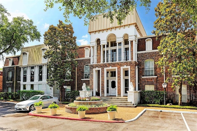 7575 Katy Fwy Unit 29, Houston, TX 77024 - view of front of home with uncovered parking, brick siding, and board and batten siding