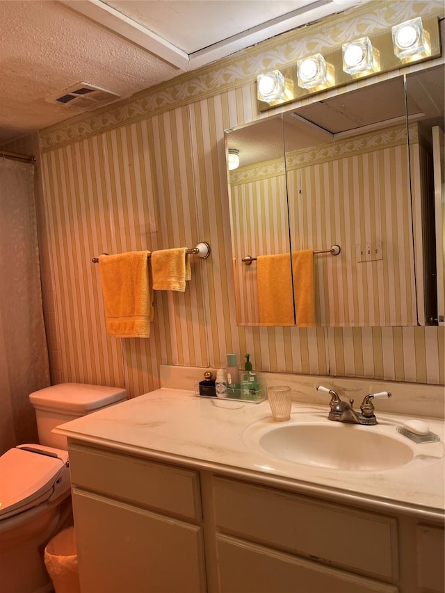 7575 Katy Fwy Unit 29, Houston, TX 77024 - bathroom with vanity, toilet, and wallpapered walls
