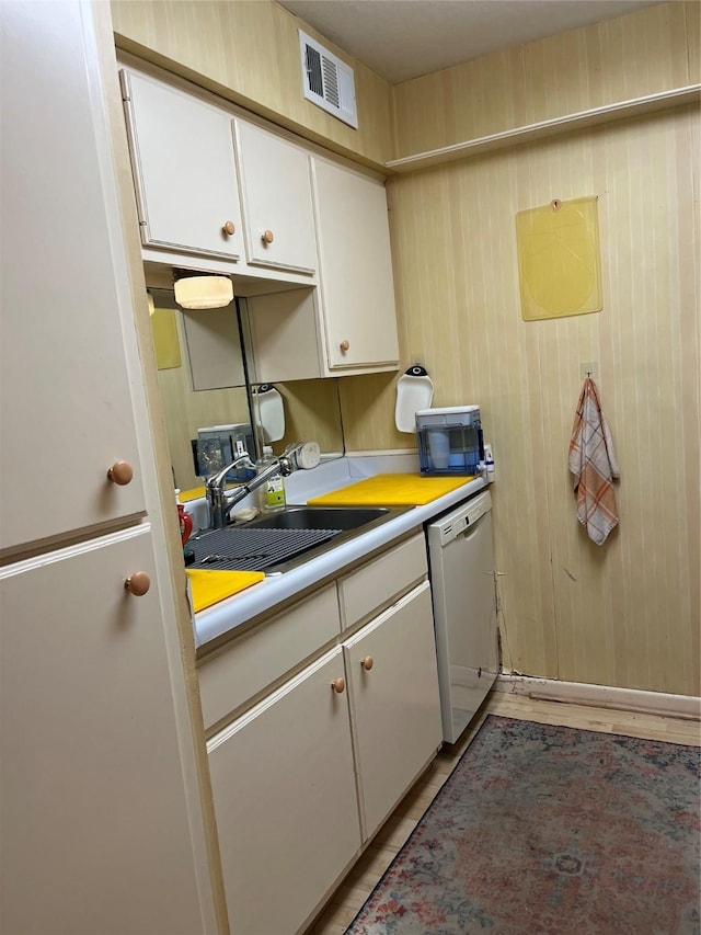 7575 Katy Fwy Unit 29, Houston, TX 77024 - kitchen featuring dishwasher, a sink, white cabinets, light countertops, and black microwave