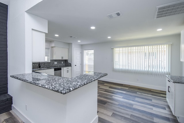 7418 Dew Mist Ln, Houston, TX 77095 - kitchen with stainless steel dishwasher, white cabinetry, dark stone counters, baseboards, and wood finished floors