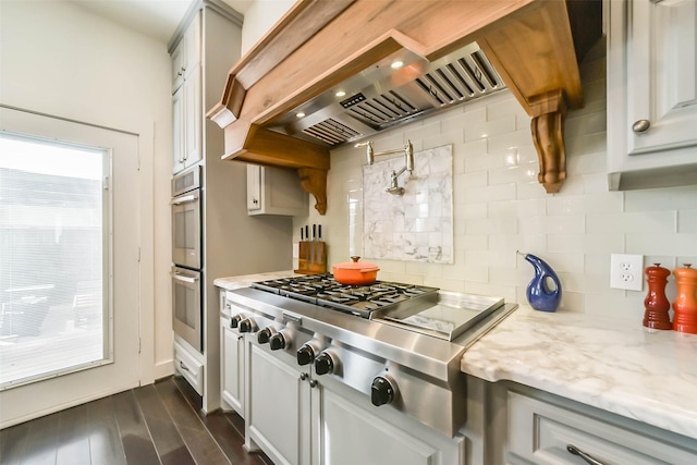 4530 Woodside St, Houston, TX 77023 - kitchen featuring custom range hood, backsplash, healthy amount of natural light, and appliances with stainless steel finishes