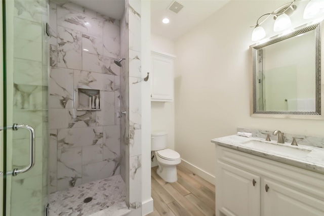 4530 Woodside St, Houston, TX 77023 - bathroom featuring a marble finish shower, vanity, wood finished floors, toilet, and baseboards