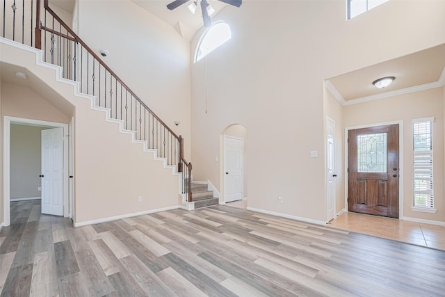 10015 Black Birch Ln, Tomball, TX 77375 - foyer entrance featuring stairway, a ceiling fan, light wood-style flooring, a towering ceiling, and crown molding