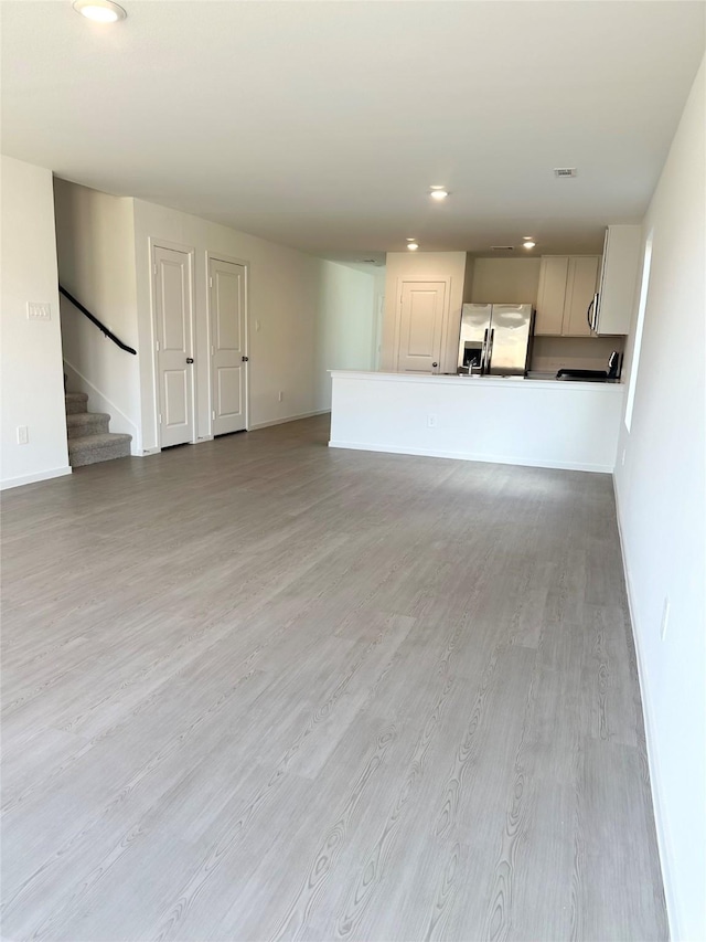 16477 Blossom Grove Dr, Conroe, TX 77303 - unfurnished living room with baseboards, recessed lighting, wood finished floors, and stairs