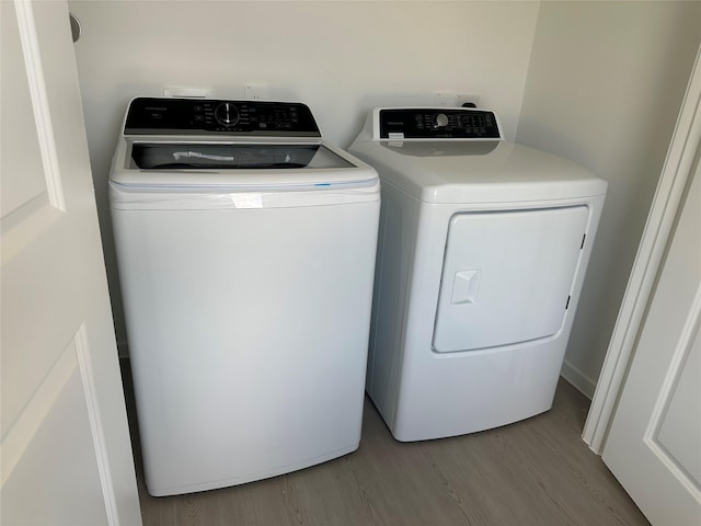 16477 Blossom Grove Dr, Conroe, TX 77303 - laundry room with wood finished floors and washing machine and clothes dryer