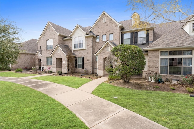 2411 Clippers Sq, Houston, TX 77058 - view of front facade featuring brick siding, roof with shingles, and a front lawn