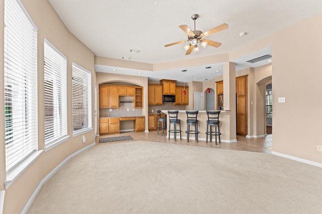 2411 Clippers Sq, Houston, TX 77058 - kitchen featuring arched walkways, open shelves, a breakfast bar, black microwave, and ceiling fan