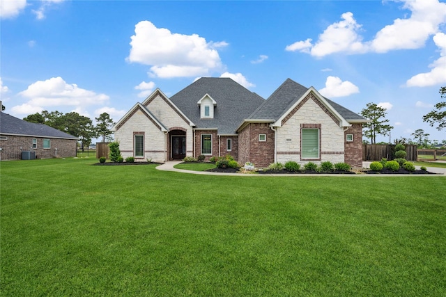 5219 Camp Creek Rd, Baytown, TX 77523 - french country style house featuring stone siding, brick siding, cooling unit, and roof with shingles