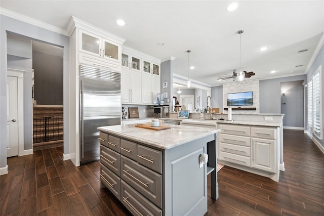 5219 Camp Creek Rd, Baytown, TX 77523 - kitchen with built in fridge, a peninsula, white cabinetry, dark wood-style flooring, and baseboards