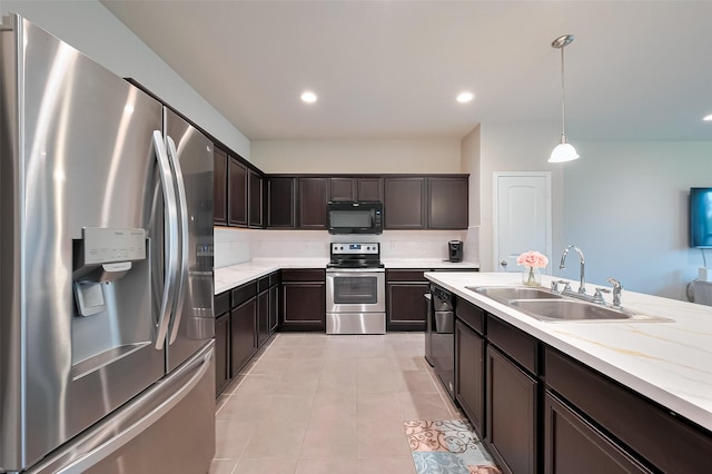 2535 Sandbar Shark Ct, Katy, TX 77449 - kitchen featuring appliances with stainless steel finishes, a sink, dark brown cabinetry, light tile patterned floors, and decorative light fixtures