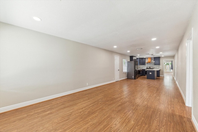 905 E 39th St, Houston, TX 77022 - unfurnished living room featuring light wood-style floors, recessed lighting, and baseboards
