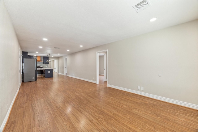 905 E 39th St, Houston, TX 77022 - unfurnished living room featuring light wood-type flooring, baseboards, and recessed lighting