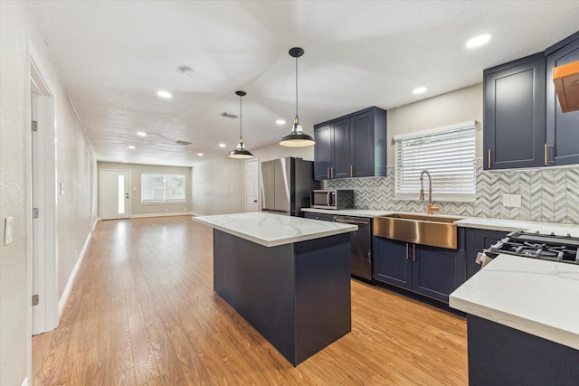 905 E 39th St, Houston, TX 77022 - kitchen with a sink, stainless steel appliances, a kitchen island, light wood-style flooring, and recessed lighting