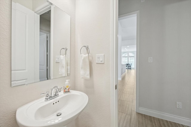 2314 Umber Oaks Ln, Brookshire, TX 77423 - bathroom featuring a sink, baseboards, and wood finished floors