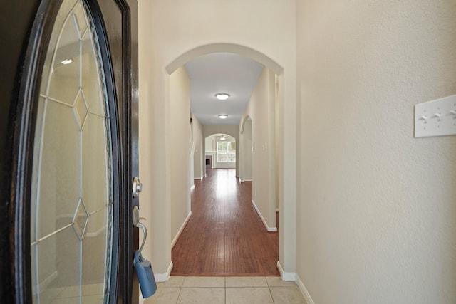 8727 Debbie Terrace Dr, Cypress, TX 77433 - corridor featuring arched walkways, baseboards, and light tile patterned floors