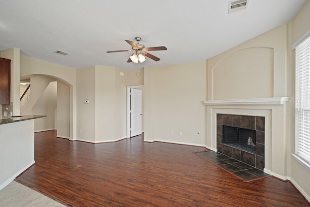 8727 Debbie Terrace Dr, Cypress, TX 77433 - unfurnished living room with a ceiling fan, wood finished floors, arched walkways, and a fireplace