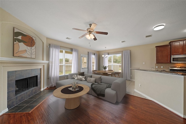 8727 Debbie Terrace Dr, Cypress, TX 77433 - living area featuring wood finished floors, ceiling fan, a tiled fireplace, and baseboards