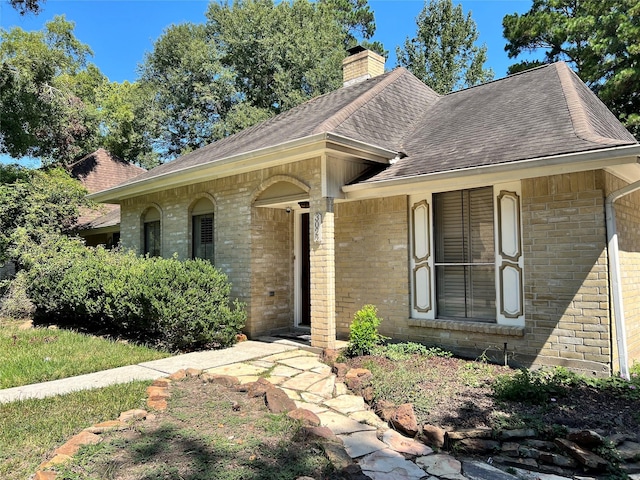 3022 Falling Brook Dr, Kingwood, TX 77345 - view of front of home featuring brick siding, roof with shingles, and a chimney